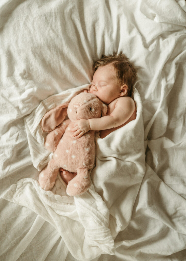 Cincinnati in home photographer documenting newborn snuggling stuffy