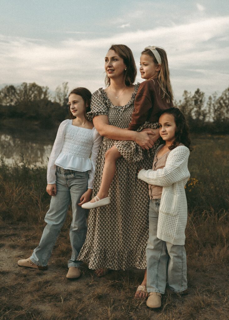 Mother holding her child near a pond at golden hour captured by a Cincinnati family photographer