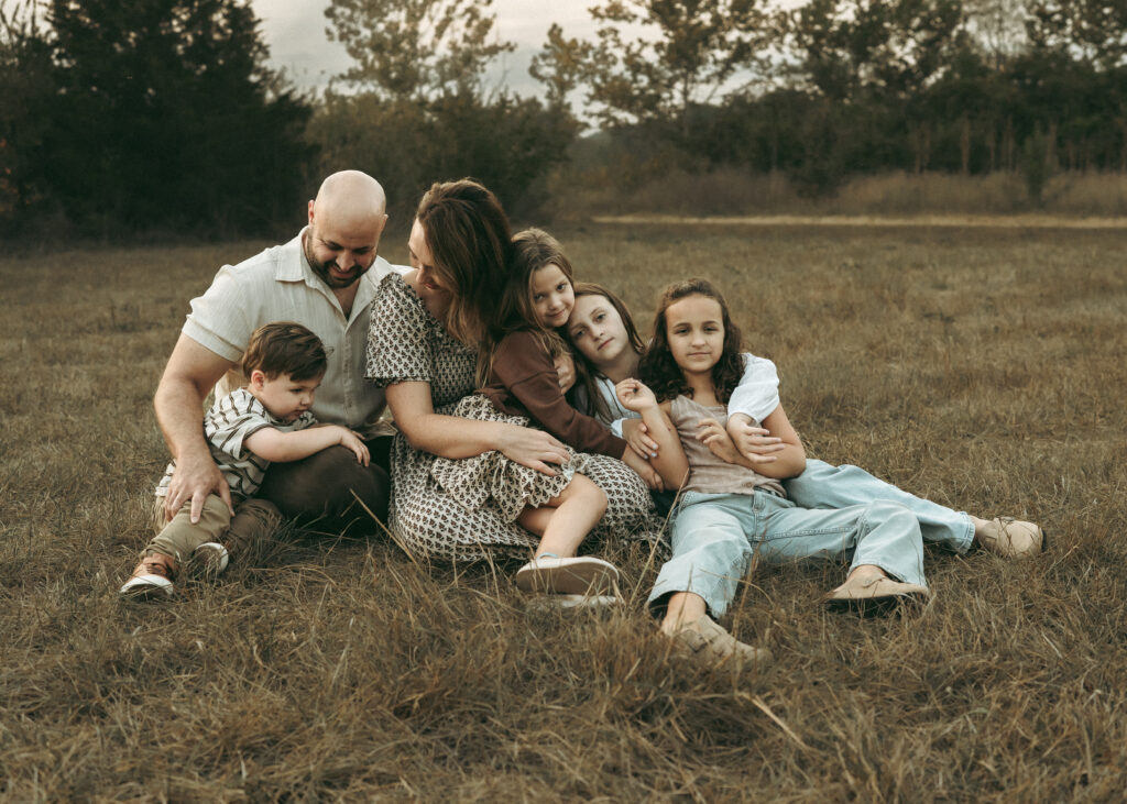 Family snuggling together during a warm sunset session at a pond with a Cincinnati family photographer