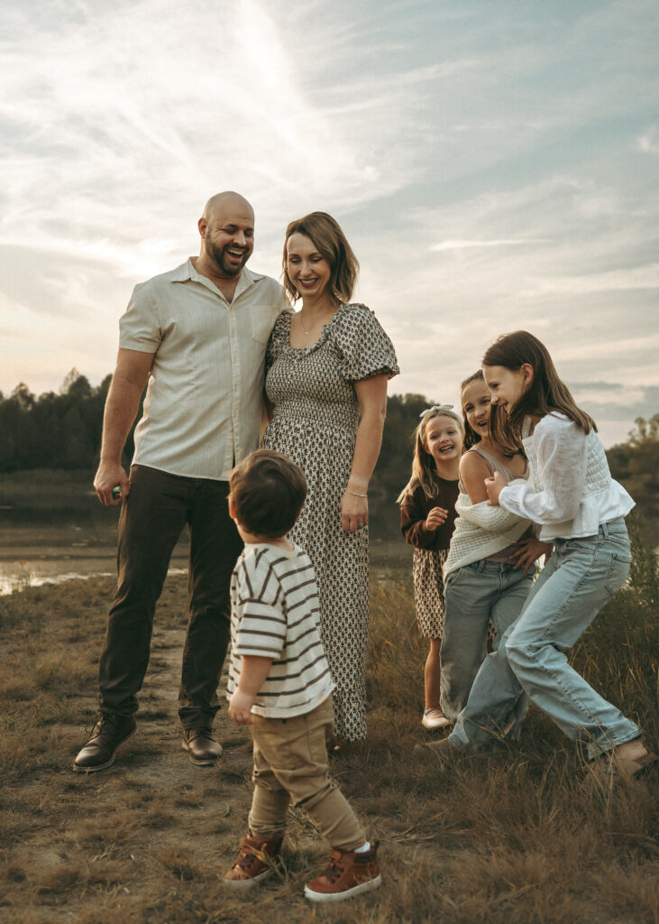 Family playing at a pond at sunset during a lifestyle session with a Cincinnati family photographer