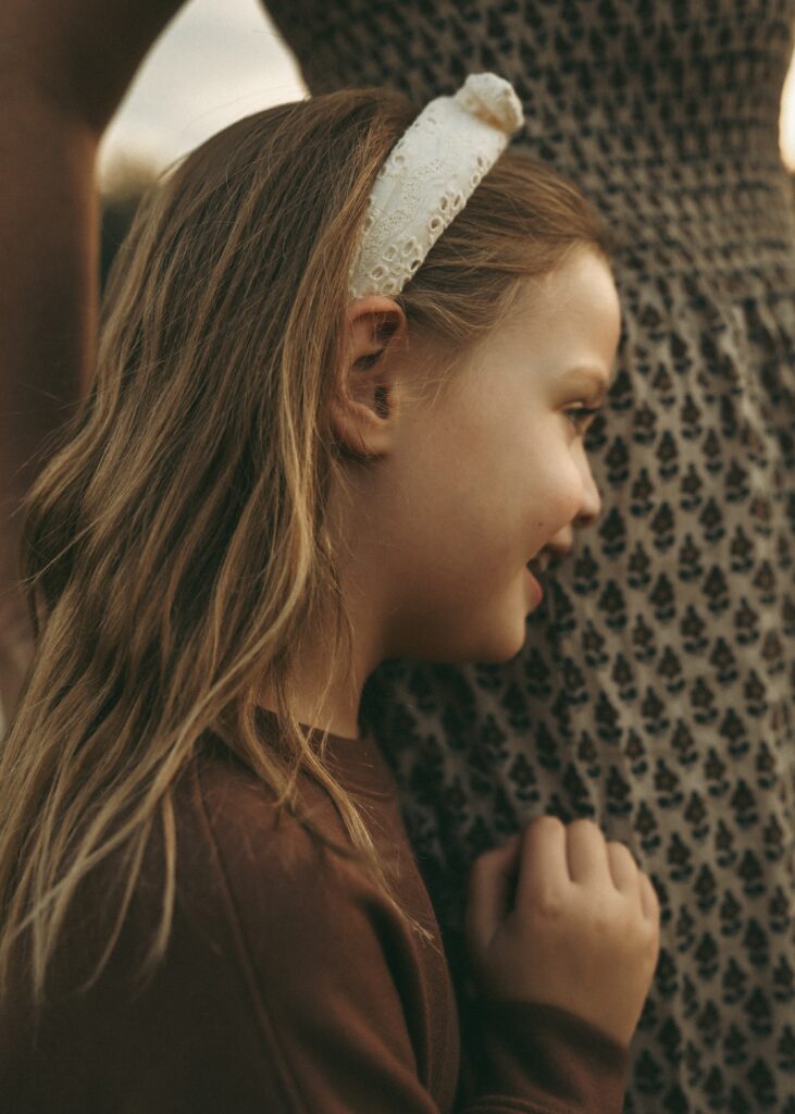 Daughter snuggling mom during a sunset session at a pond with a Cincinnati family photographer