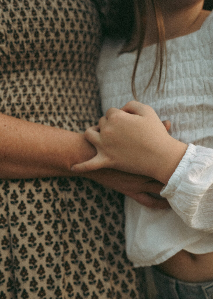 Candid detailed moment of mom and daughter snuggling during family session at a Cincinnati pond