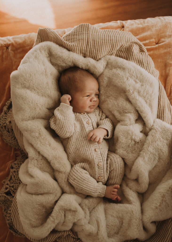 cincinnati newborn photographer safely posing baby on bed