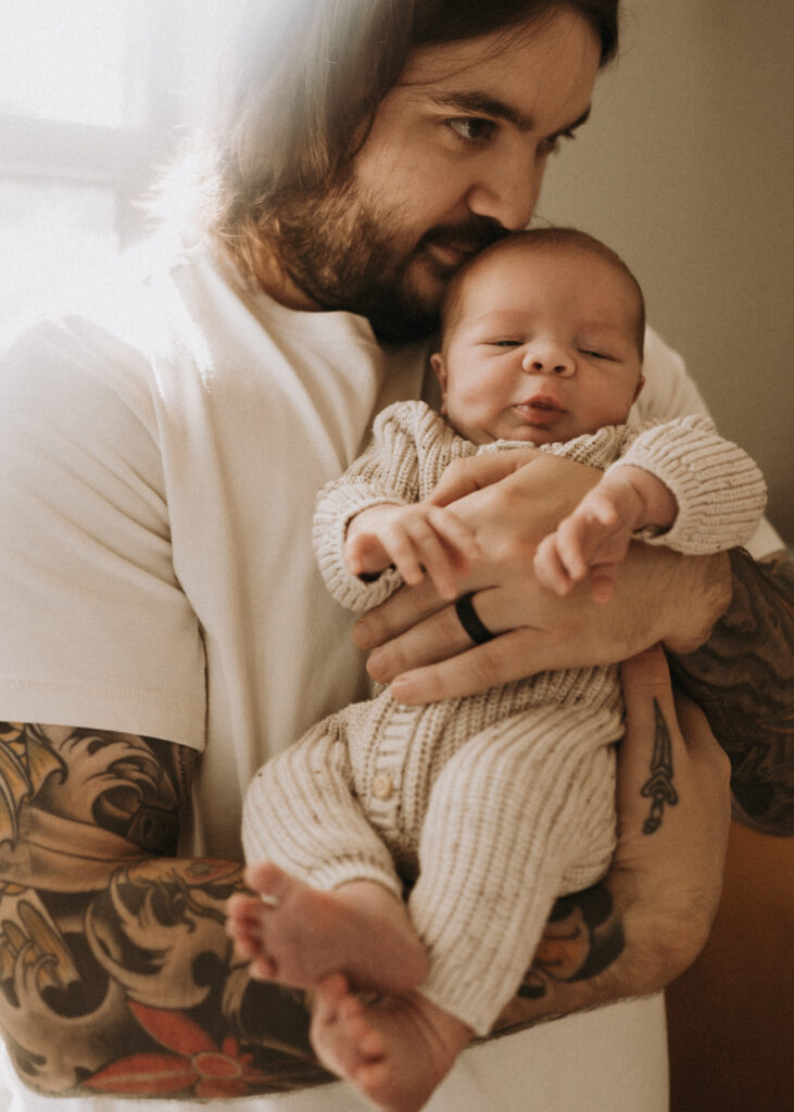 dad snuggling newborn baby during in home lifestyle session in cincinnati 