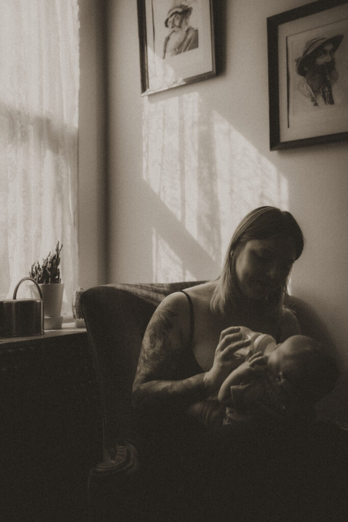 beautiful light as mother bottle feeds baby cincinnati newborn photographer