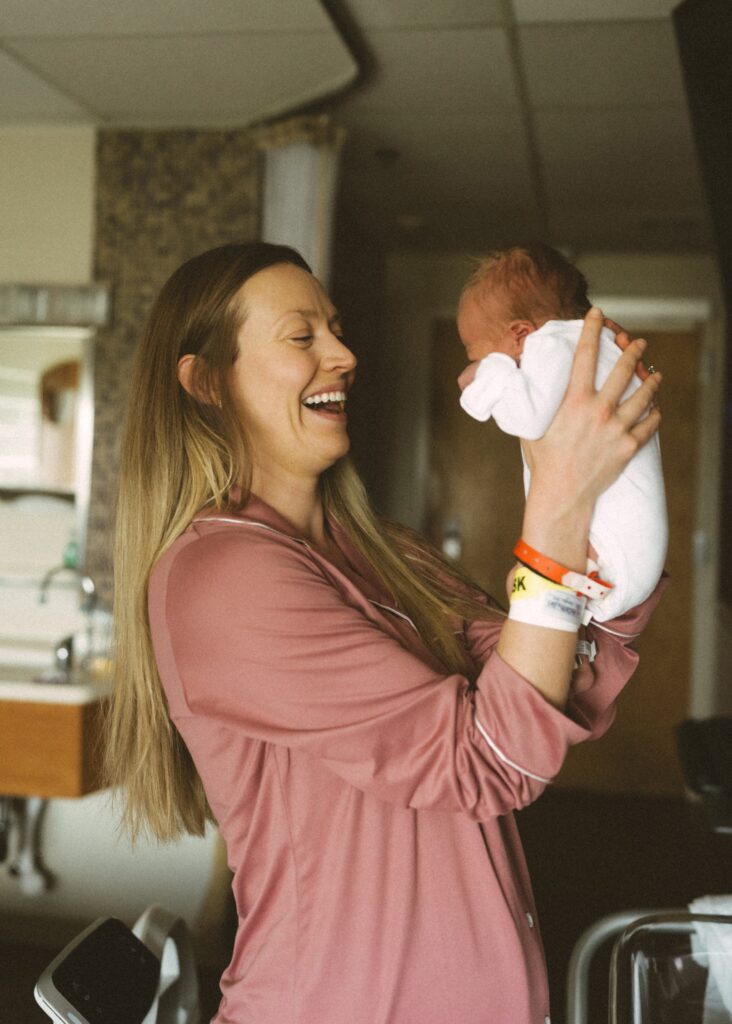mom and newborn scrunch in hospital room in cincinnati