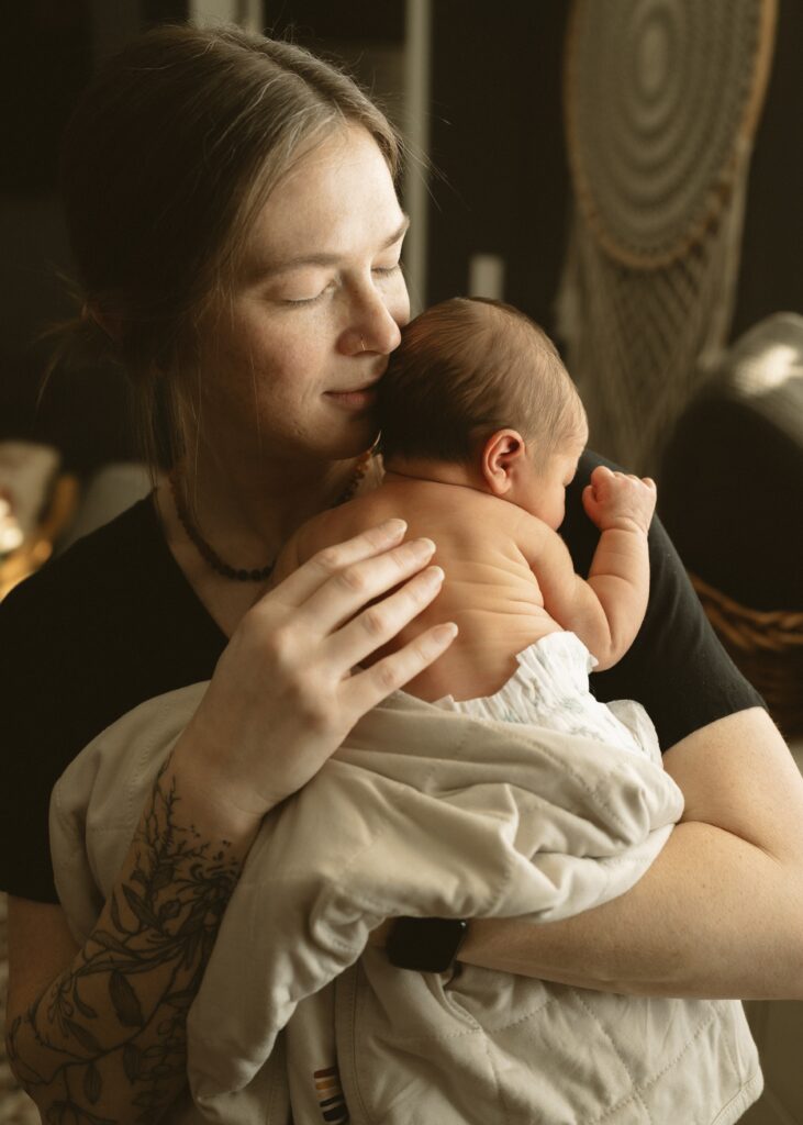 mom cuddling newborn during a cincinnati in home fresh 48 lifestyle session
