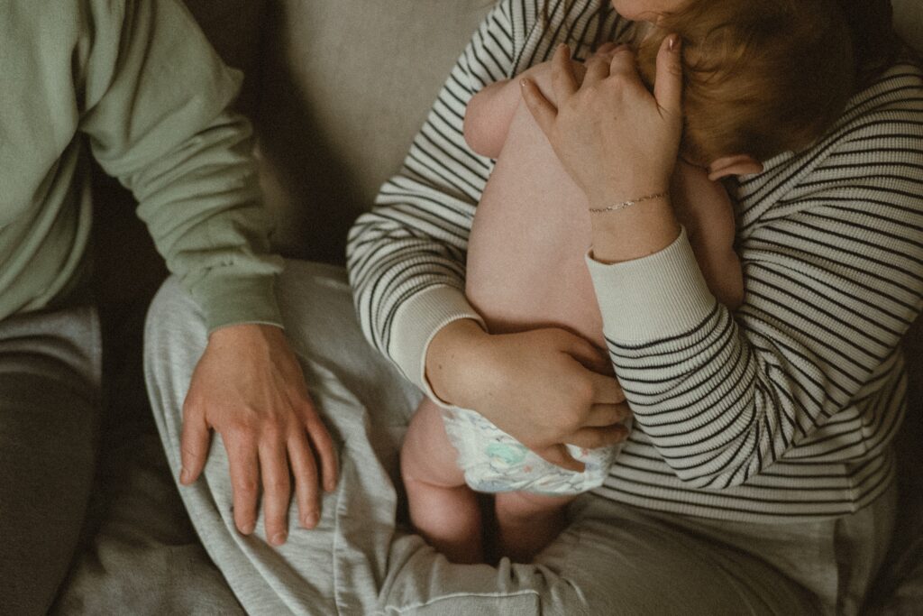 Toddler family snuggling on the couch during their in home lifestyle photo session with a cincinnati photographer.