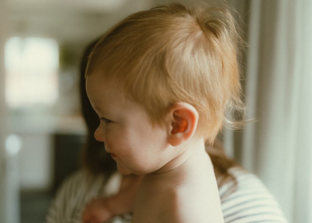 Toddler boy smiling during his family's in home session in their Cincinnati home.