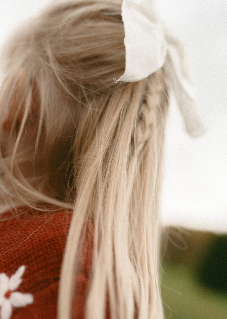 blonde toddler and white bow during lifestyle family photography session