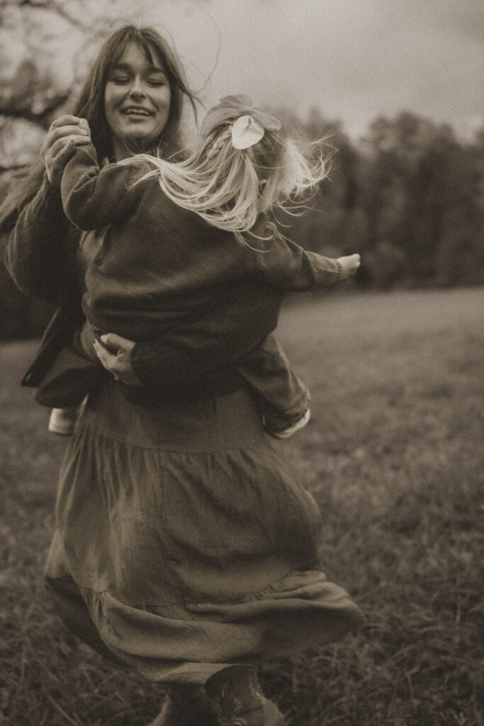 mom dancing with toddler during lifestyle child led photography session