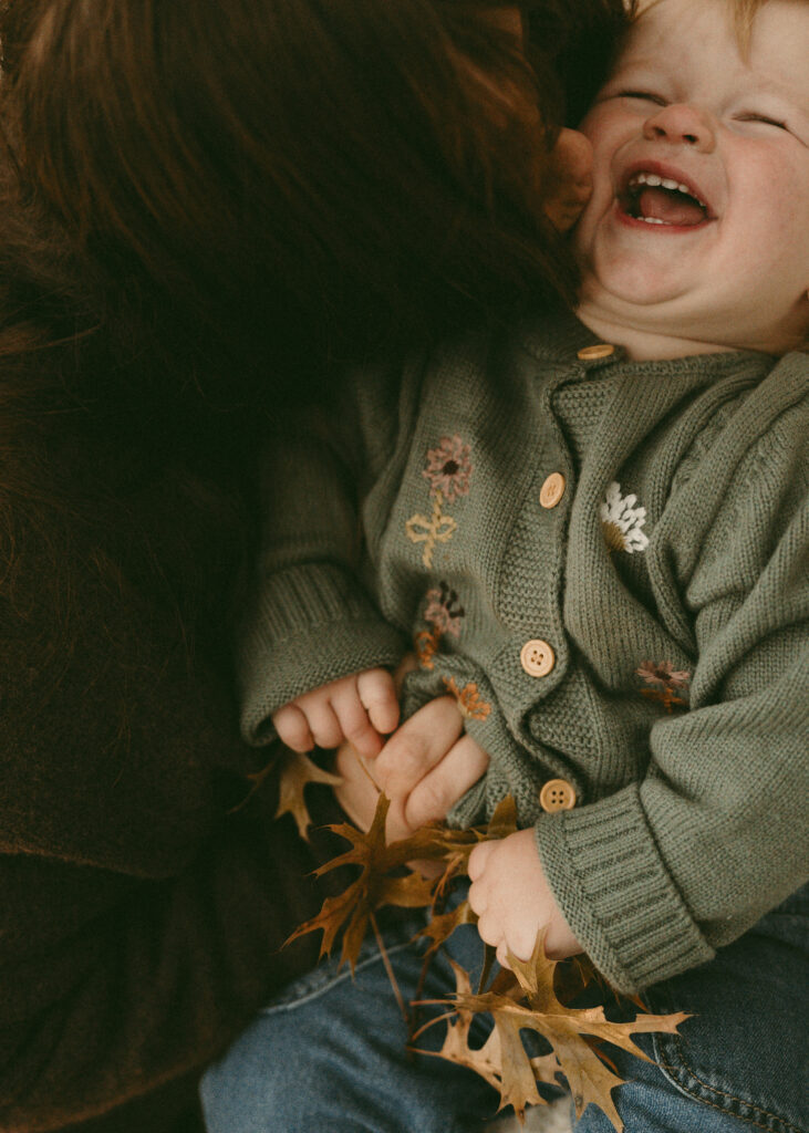 mom tickling toddler during family photos