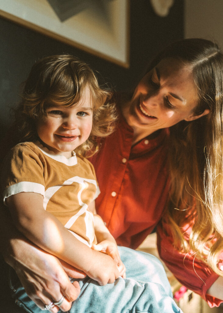 Mom an toddler boy in dappled light inside their home during their cincinnati lifestyle family photography session