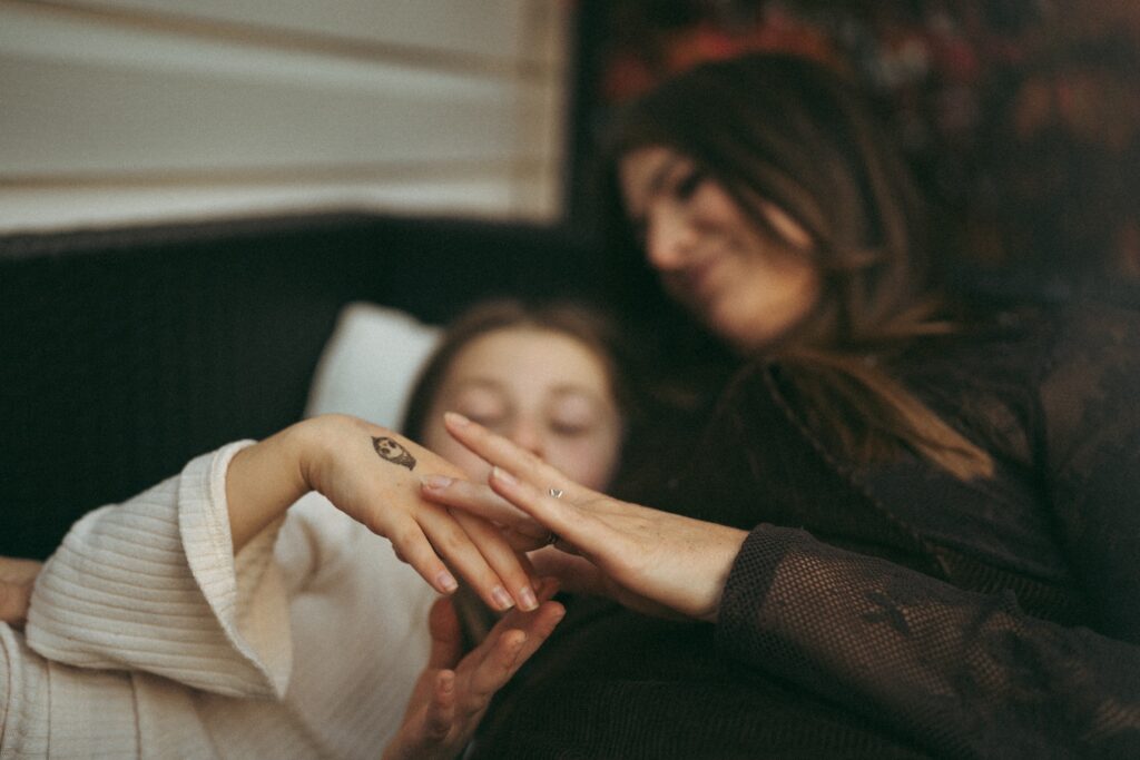 mom touching her daughter's hands with temporary tattoos
