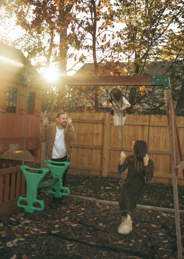 cincinnati lifestyle photographer capturing real moments with a family in their backyard playing on a swing playset