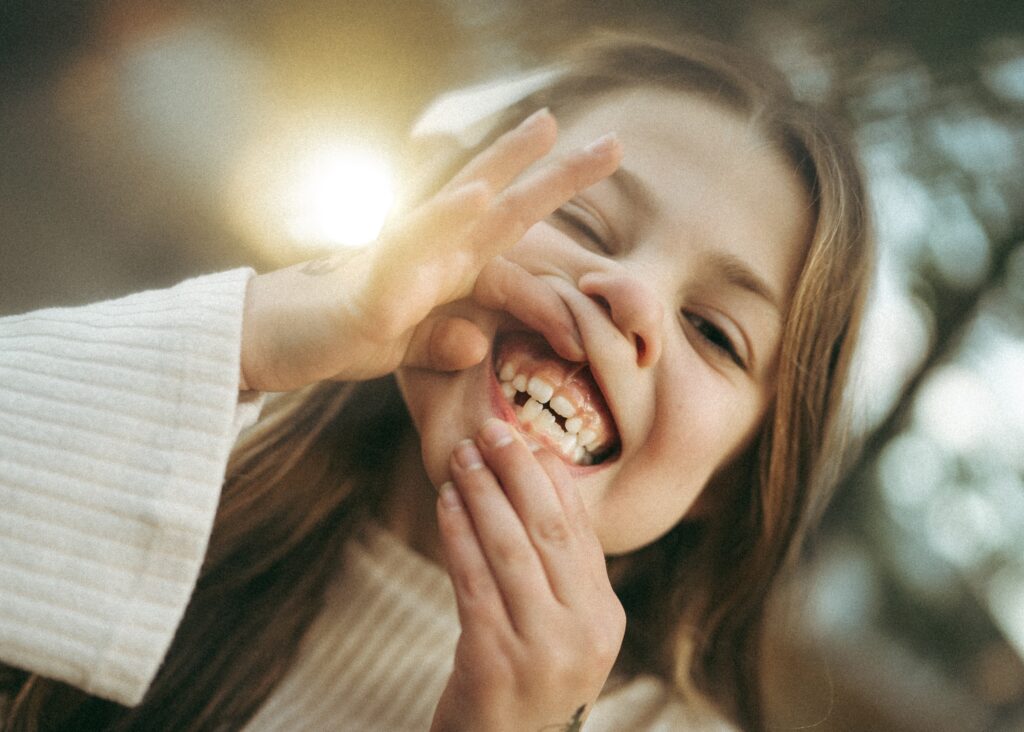 little girl showing off her new teeth during her family's lifestyle session with photographer sun and vine in cincinnati