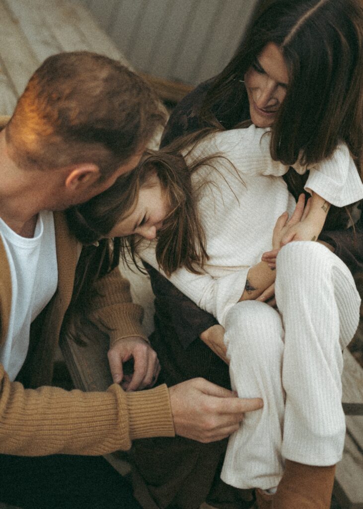Cincinnati lifestyle family photographer capturing a mom, dad, and daughter cuddling and laughing