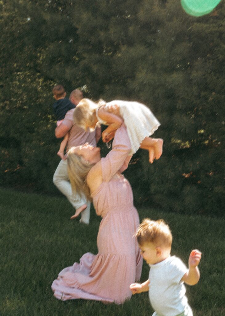 Cincinnati lifestyle photographer capturing blurry image of family playing in their yard