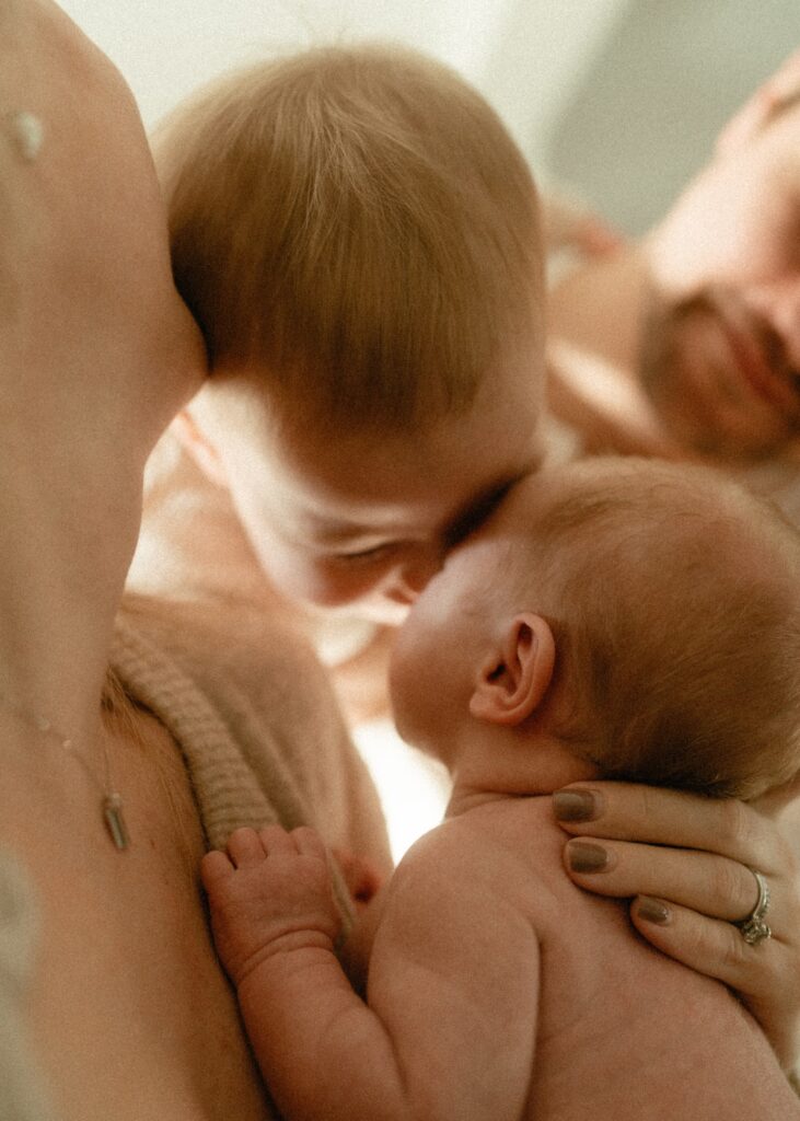 family of 4 snuggling their heads together during their newborn session