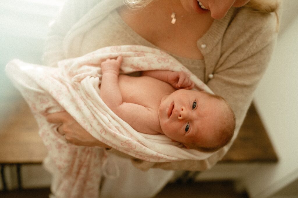 newborn girl wrapped in pink bow blanket for her newborn session in cincinnati
