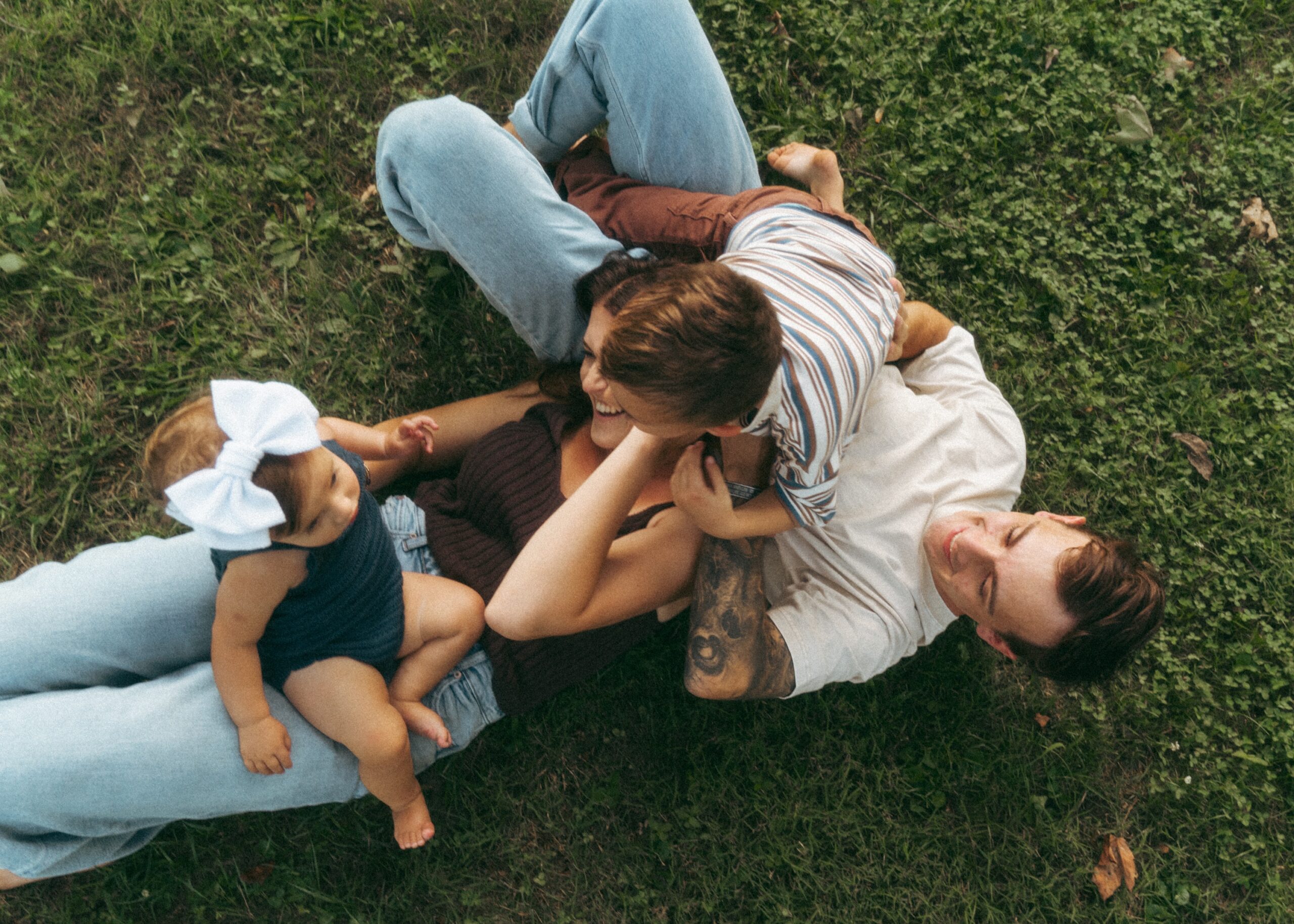 Family snuggling on the ground during their lifestyle family photography session in Cincinnati