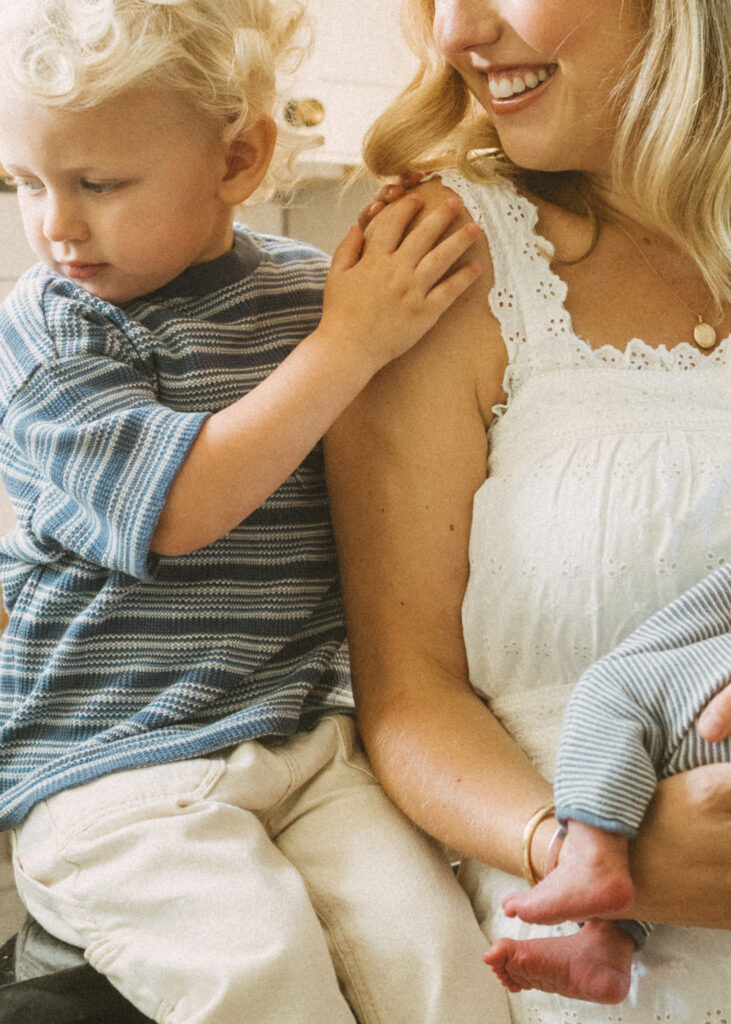toddler boy embracing his mom in a white dress during their photography session in northern kentucky