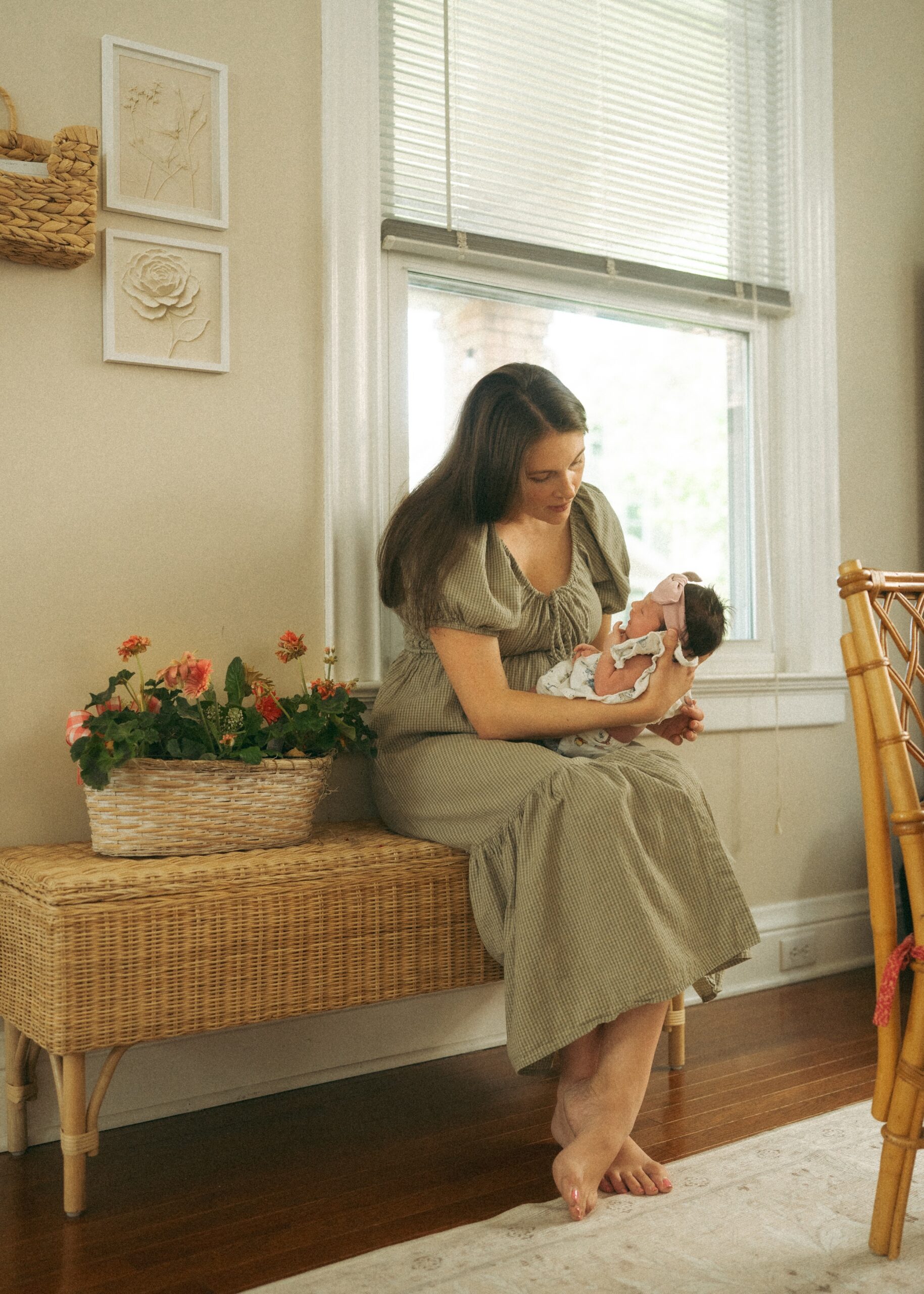 Mom holding her newborn baby sitting on a bench admiring her during her cincinnati newborn photography session